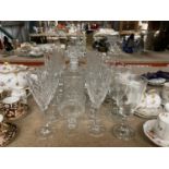 A QUANTITY OF GLASSES TO INCLUDE A DECANTER, CHAMPAGNE FLUTES, WINE GLASSES, ETC