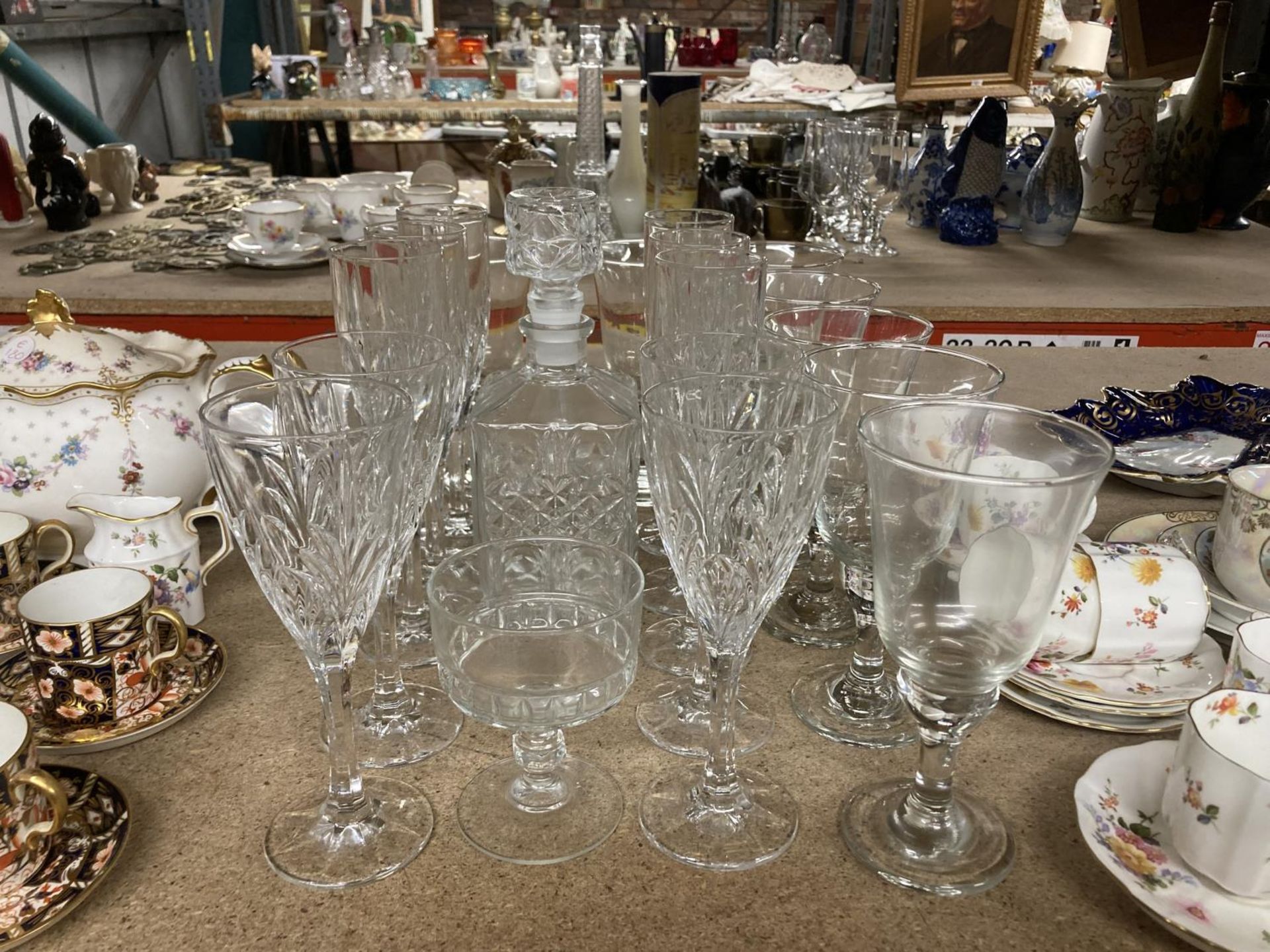 A QUANTITY OF GLASSES TO INCLUDE A DECANTER, CHAMPAGNE FLUTES, WINE GLASSES, ETC