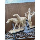 A RESIN FIGURE OF FEMALE WALKING TWO DOGS AND A SMALL METAL FIGURE OF A YOUNG BOY