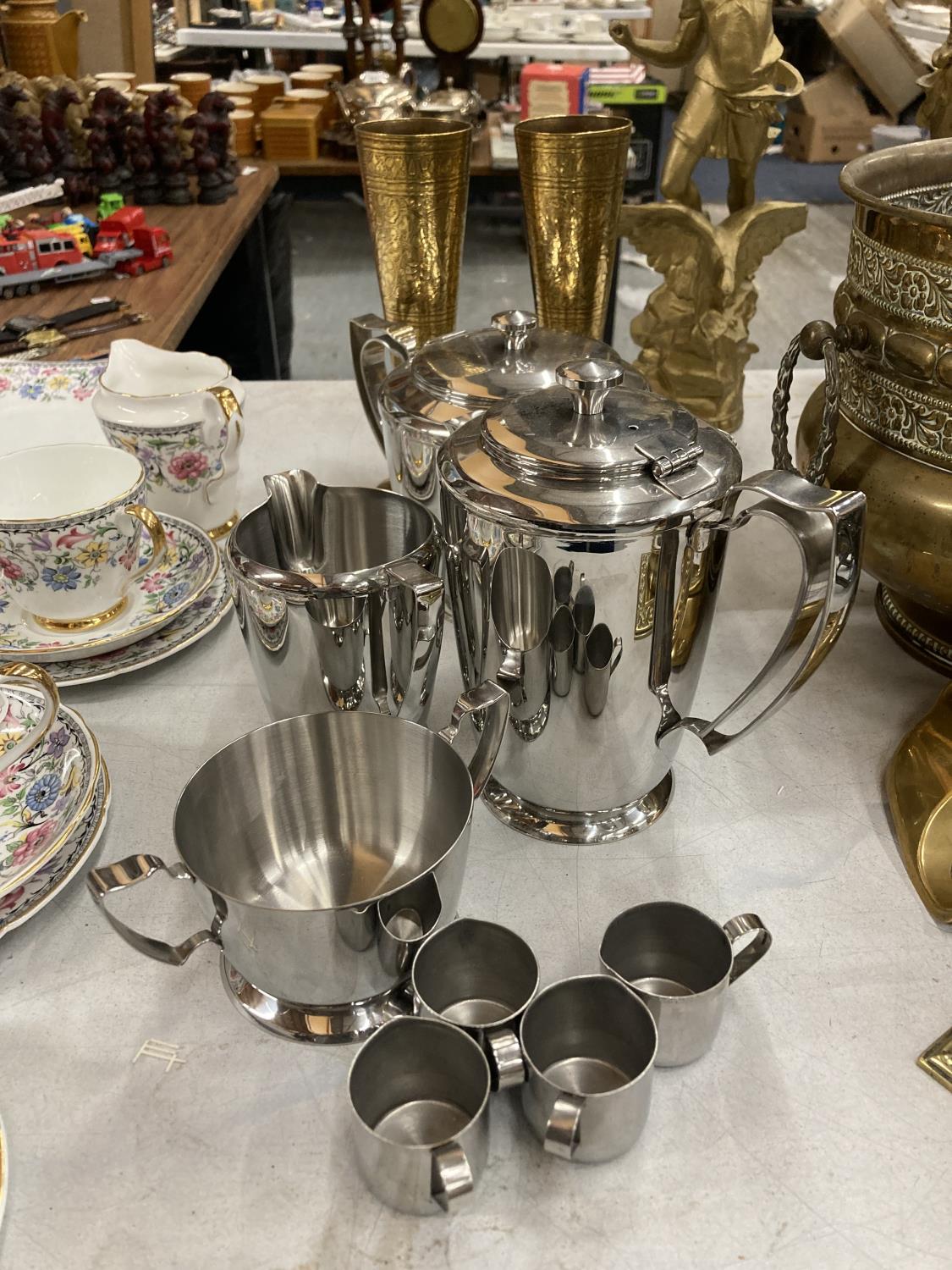 A STAINLESS STEEL TEASET TO INCLUDE A TEAPOT, HOT WATER JUG, SUGAR BOWL, CREAM JUG, SMALL MILK