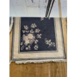 A BLUE AND CREAM PATTERNED FRINGED RUG
