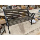 A WOODEN SLATTED GARDEN BENCH WITH CAST IRON BENCH ENDS