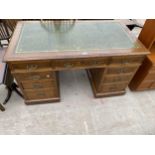 A LATE VICTORIAN OAK TWIN-PEDESTAL DESK ENCLOSING EIGHT GRADUATED DRAWERS AND CENTRAL LONG DRAWER