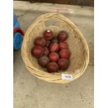 A WICKER BASKET CONTAINING A QUANTITY OF CRICKET BALLS