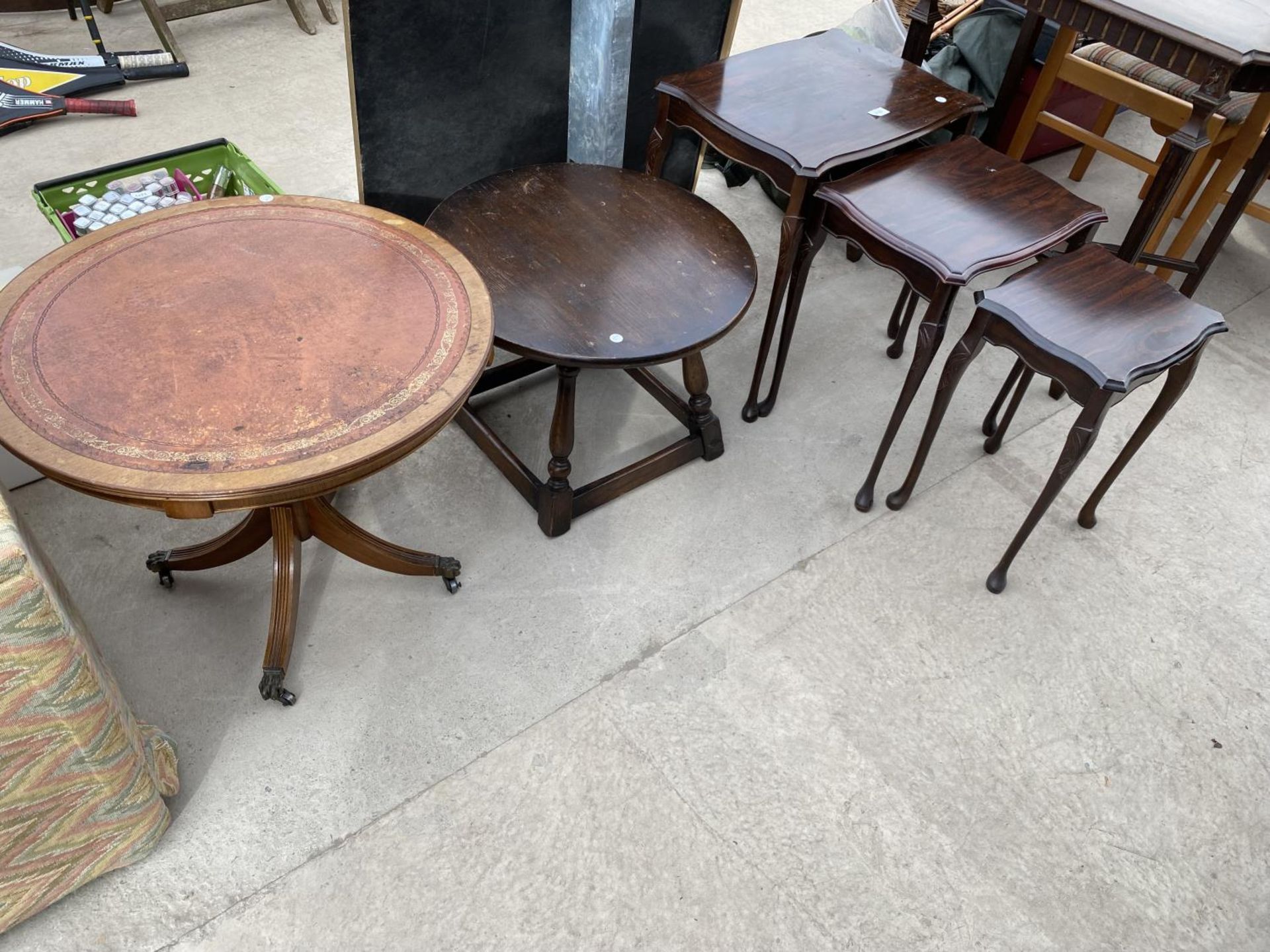 A NEST OF THREE TABLES, 22" DIAMETER, LAMP TABLE AND 24" DIAMETER TABLE WITH INSET LEATHER TOP