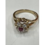 A 9 CARAT GOLD RING WITH CENTRE RUBY SURROUNDED BY CUBIC ZIRCONIAS SIZE K