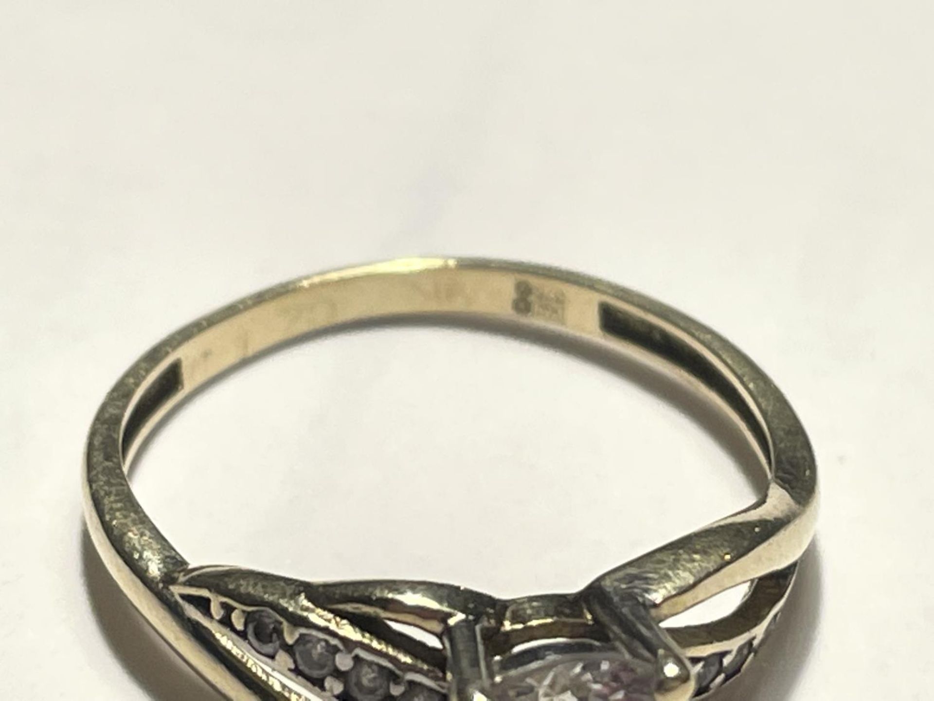 A 9 CARAT GOLD RING WITH A LARGE CENTRE CLEAR STONE AND SMALLER TO THE SHOULDERS - Image 4 of 4
