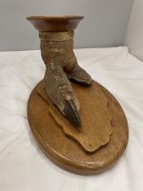 A TAXIDERMY OSTRICH FOOT ON AN OAK BASE MOUNTED WITH AN OAK PLINTH WITH BAIZE BASE AND A COPPER TRAY