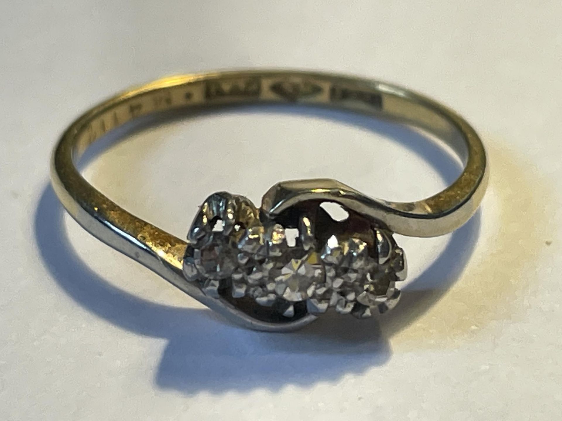 A PLATINUM RING WITH THREE IN LINE DIAMONDS SIZE L/M GROSS WEIGHT 2.01 GRAMS