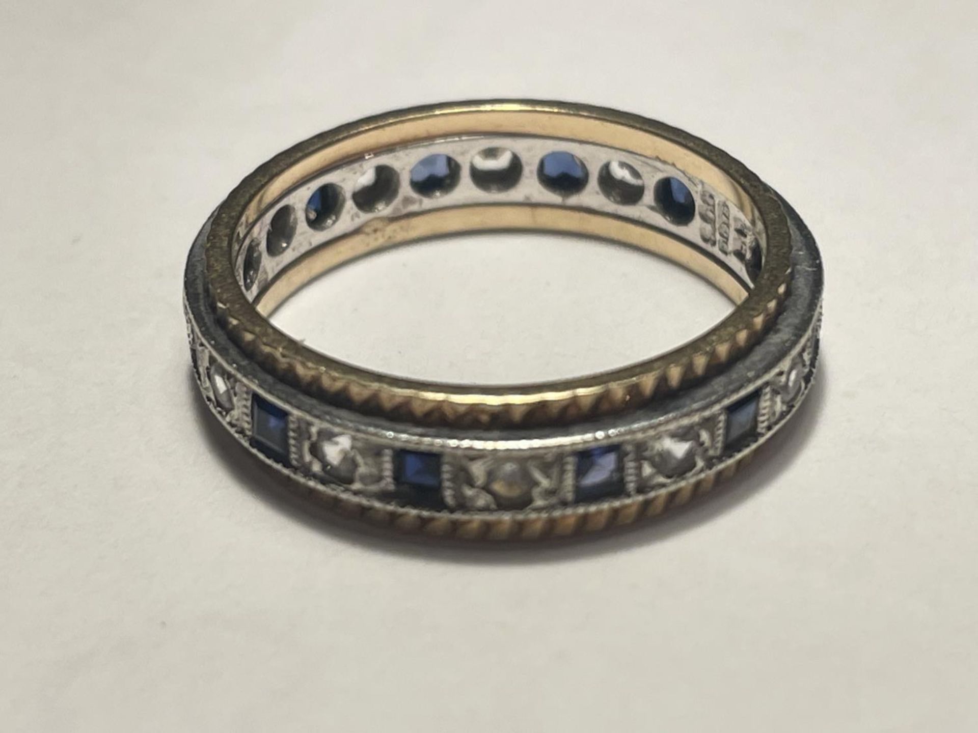 A 9 CARAT GOLD RING WITH A BAND OF SAPPHIRES AND CUBIC ZIRCONIA STONES - Image 2 of 3