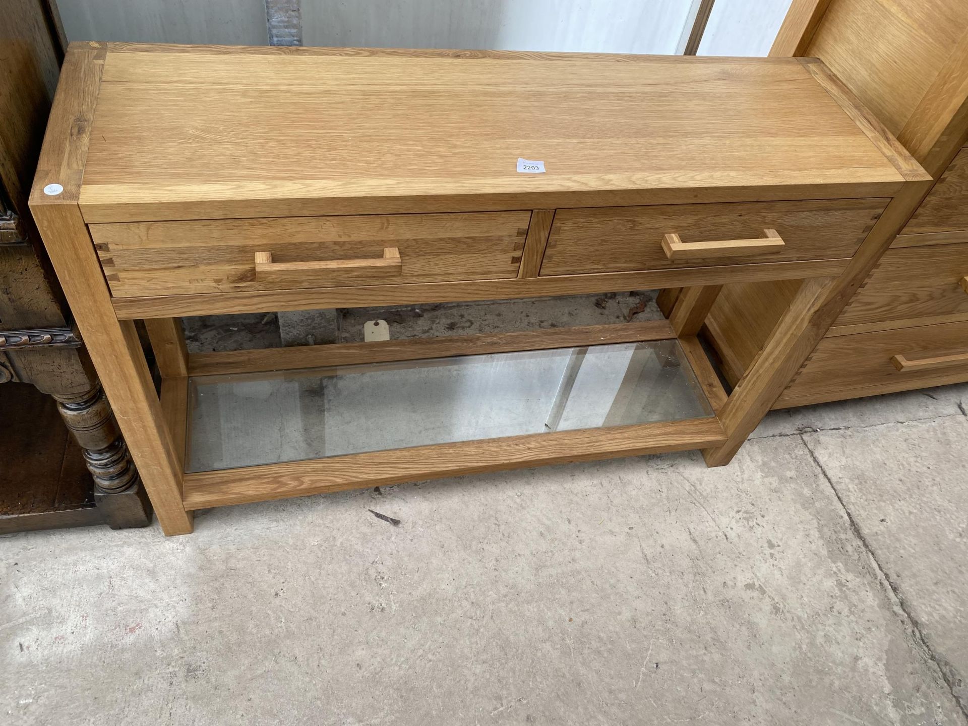 A MODERN OAK CONSOLE TABLE WITH TWO DRAWERS AND LOWER GLAZED SHELF 48" WIDE