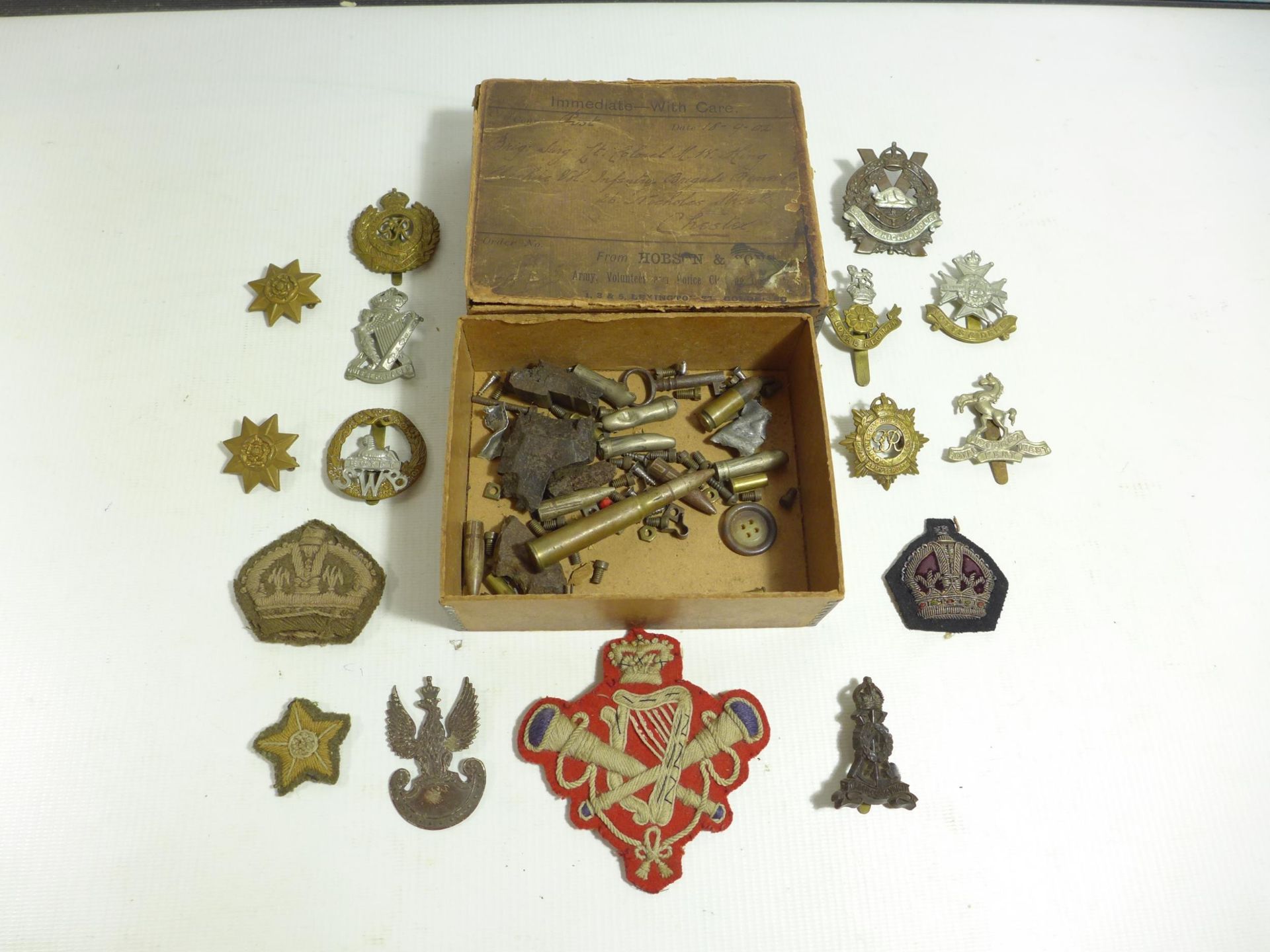 A BOER WAR PERIOD BOX CONTAINING NUMEROUS WORLD WAR I AND WORLD WAR II BADGES TO INCLUDE POLISH ARMY