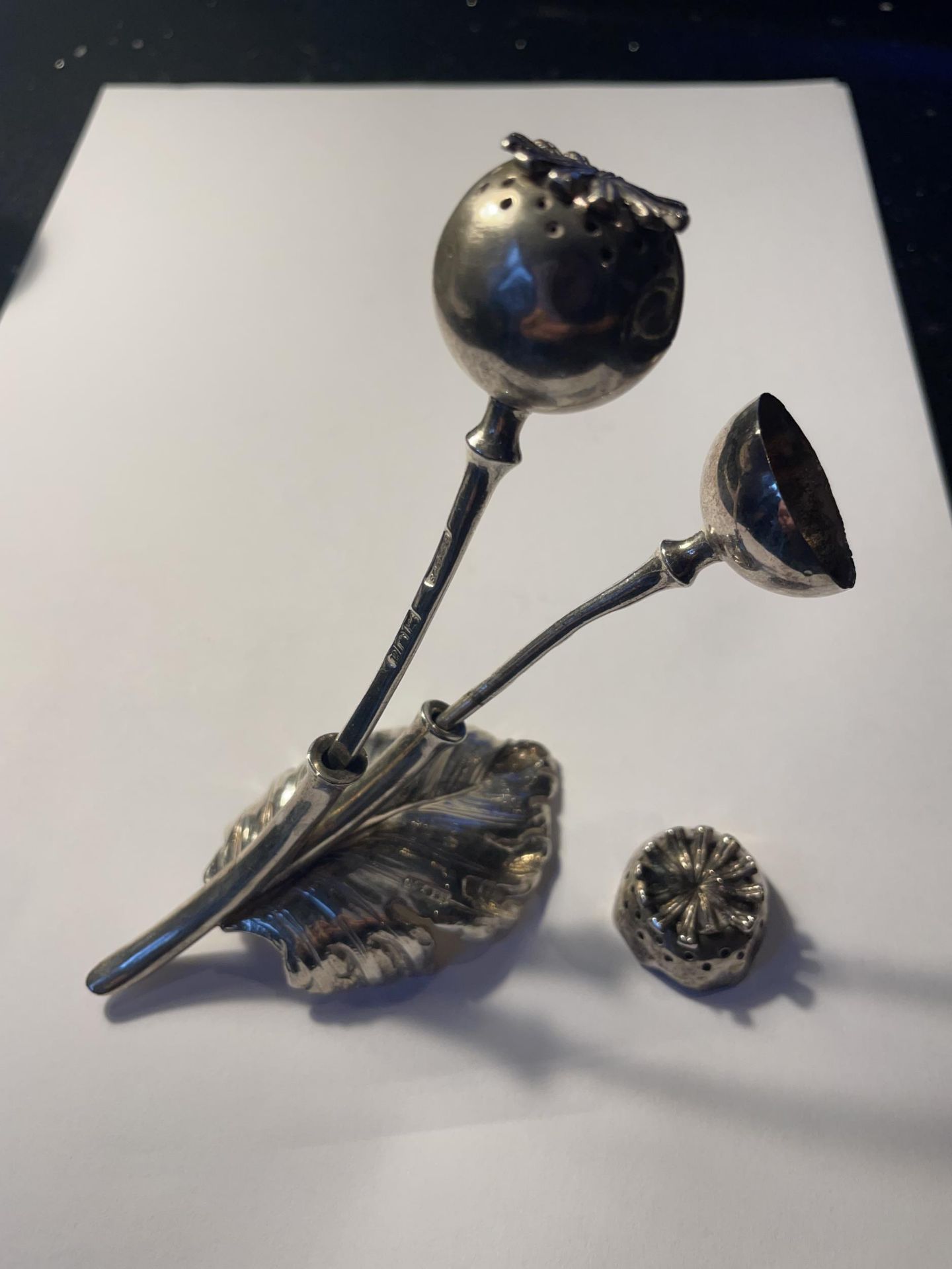 A HALLMARKED LONDON SILVER POPPY SEED HEAD VINIGARETTE ON A LEAF DESIGN HOLDER (ONE POPPY HEAD A/F)