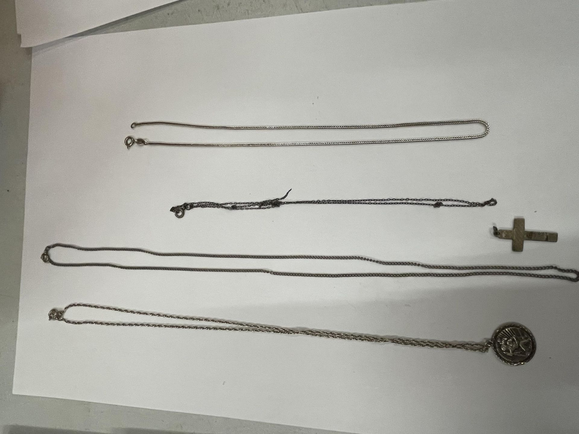 FOUR SILVER NECKLACES WITH A ST CHRISTOPHER AND A CROSS