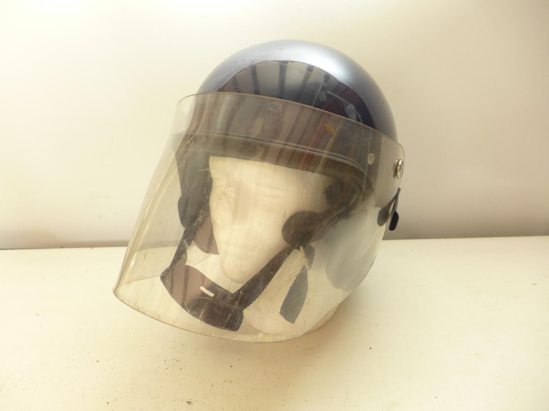 A POLICE RIOT HELMET AND FACE SHIELD