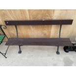 A WOODEN PLANK BENCH WITH CAST IRON LEG SUPPORTS
