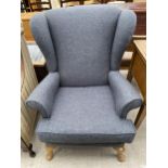 A PARKER KNOLL WINGED FIRESIDE CHAIR ON FRONT CABRIOLE LEGS