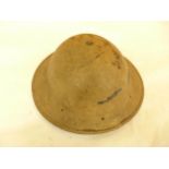 A WORLD WAR II DESERT COLOURED PAINTED BRODIE HELMET AND LINEN