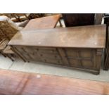 A REPRODUCTION DRESSER BASE ENCLOSING TWO CUPBOARDS AND THREE DRAWERS 74" WIDE