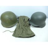 A GERMAN METAL HELMET AND LINER, GREEN PAINTED METAL HELMET AND A CAMOUFLAGE HOOD