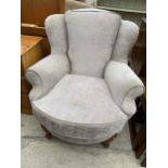 A CHARLES & LOU EPSTEIN WINGED AND UPHOLSTERED EASY CHAIR ON SHORT FRONT CABRIOLE LEGS