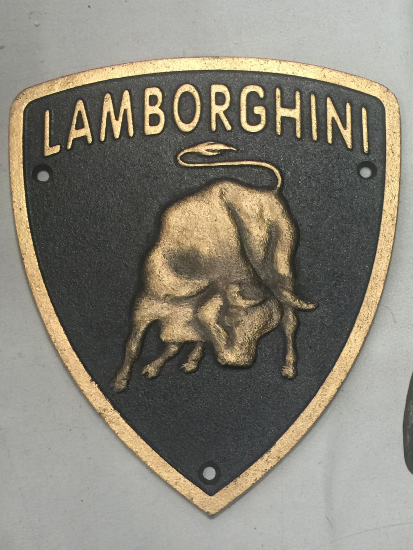 A CAST SHIELD SHAPED LAMBORGHINI SIGN 19CM X 22CM