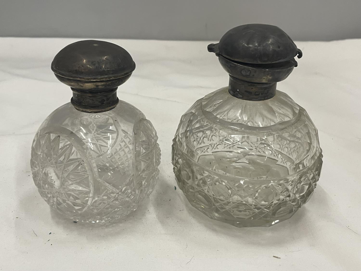 TWO CUT GLASS BOTTLES WITH HALLMARKED SILVER TOPS ONE BIRMINGHAM ONE CHESTER