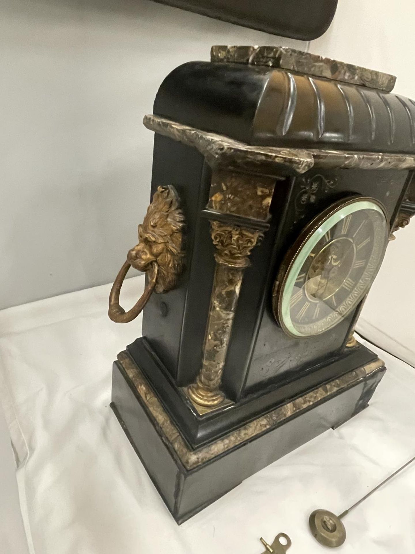 A HEAVY SLATE AND MARBLE MANTLE CLOCK WITH ENGRAVED FLOWER DECORATION AND LION HANDLES TO THE SIDE - Image 3 of 7