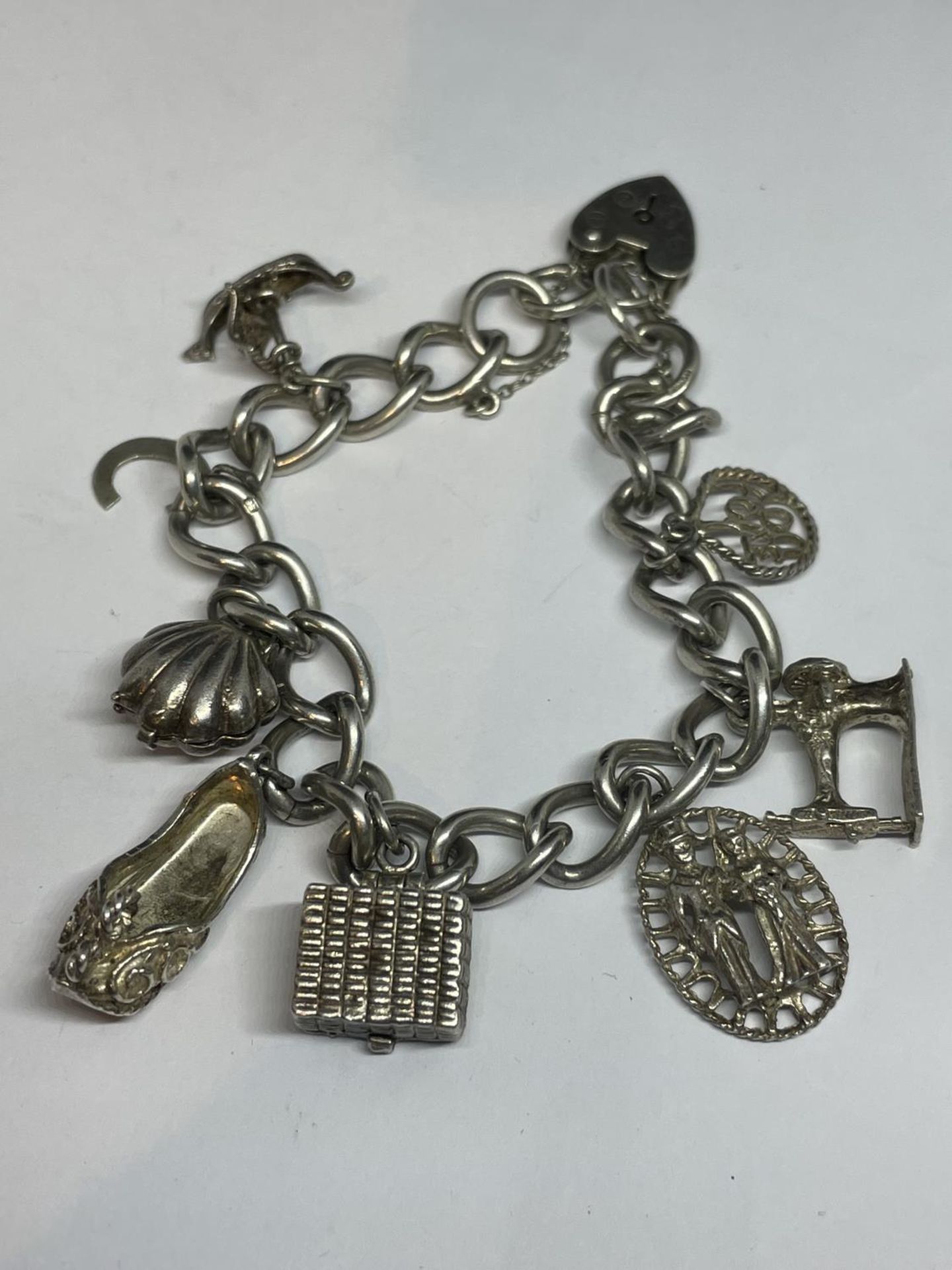 A SILVER CHARM BRACELET WITH EIGHT CHARMS