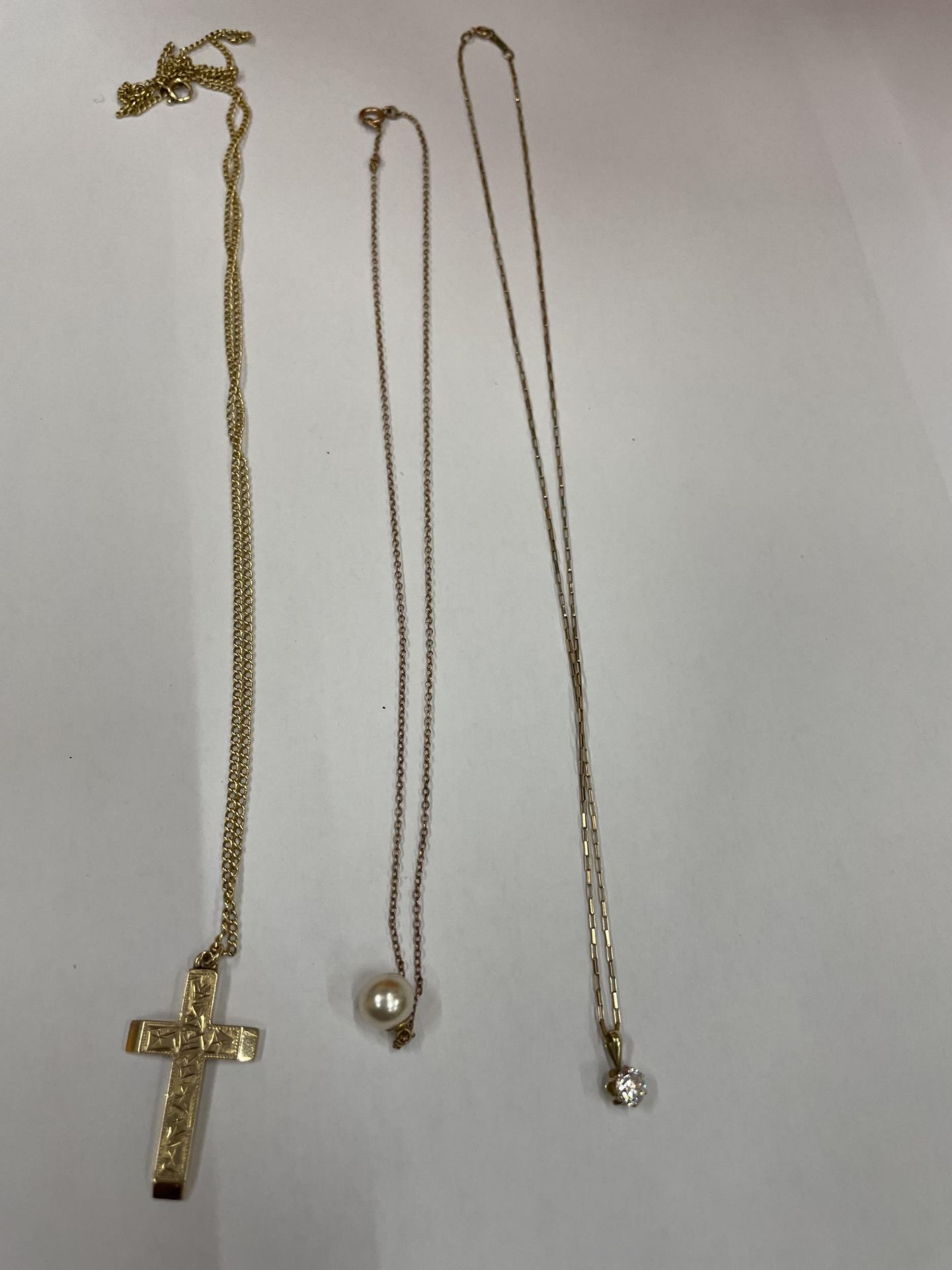 THREE NECKLACES WITH PENDANTS TO INCLUDE, TWO 9 CARAT GOLD ONE WITH A PEARL AND ONE WITH A CLEAR