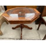 AN OCTAGONAL INDIAN HARDWOOD CARVED AND BRASS INLAID OCASIONAL TABLE WITH GLASS TOP, 27" ACROSS MAX