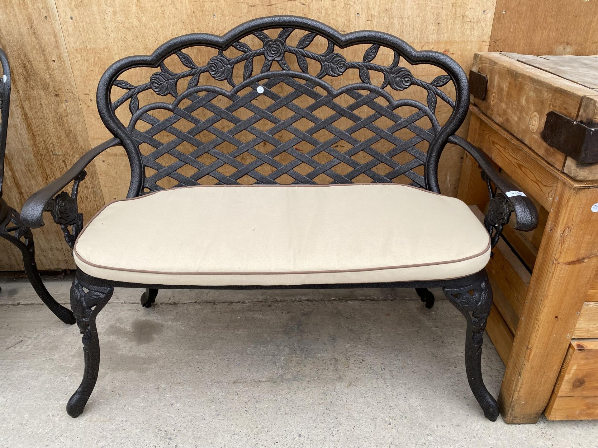 A CAST ALLOY TWO SEATER GARDEN BENCH WITH CUSHION (L:107CM)