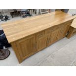 A MODERN OAK SIDEBOARD ENCLOSING FOUR CUPBOARDS AND THREE DRAWERS, 71" WIDE