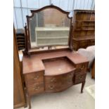 AN EDWARDIAN MAHOGANY BOWFRONTED DRESSING TABLE ENCLOSING FOUR SHORT, TWO LONG AND THREE JEWELLED