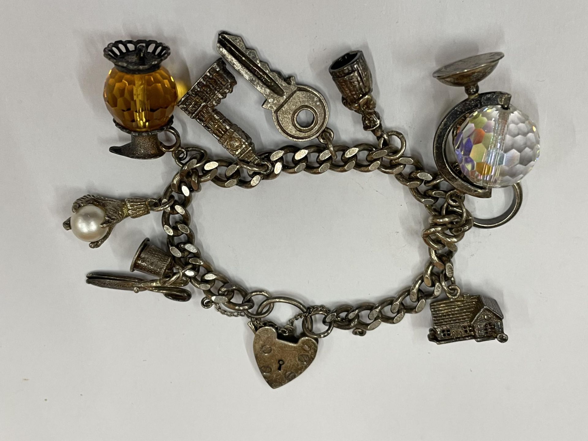 A SILVER CHARM BRACELET WITH TEN CHARMS