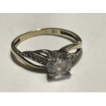 A 9 CARAT GOLD RING WITH A LARGE CENTRE CLEAR STONE AND SMALLER TO THE SHOULDERS