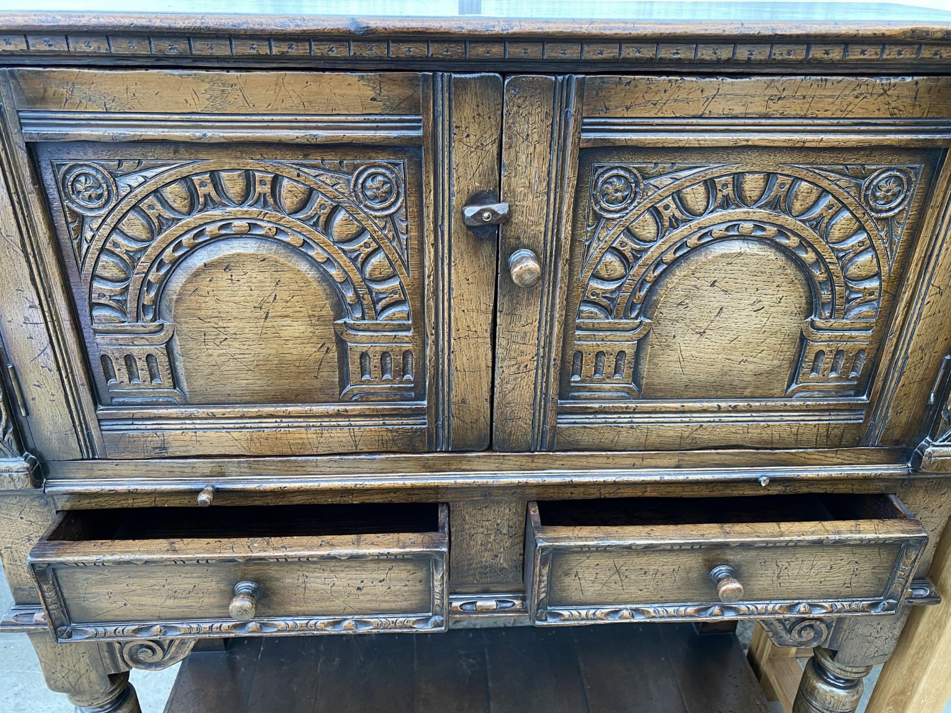 AN OAK JACOBEAN STYLE COCKTAIL CABINET WITH PANELLED DOOR, PULL OUT SLIDE, TWO DRAWERS AND A POT - Image 5 of 7