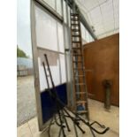 A VINTAGE WOODEN TWO SECTION 30 RUNG EXTENDABLE LADDER