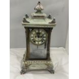 AN ANTIQUE MANTLE CLOCK WITH BEVELLED GLASS CASE WITH GLASS FRAME, PALE CERAMIC FOOTED BASE AND