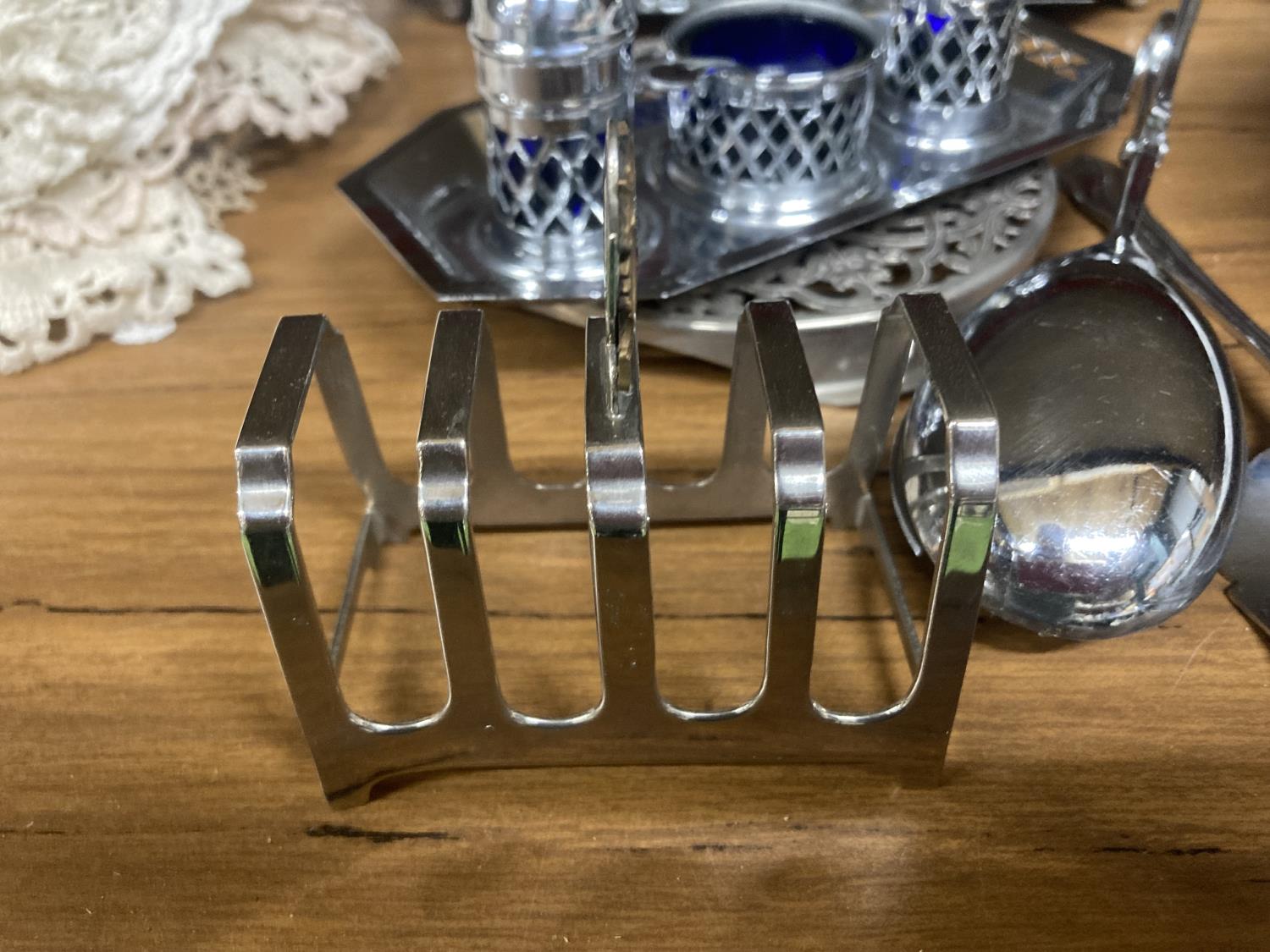 A QUANTITY OF SILVER PLATED ITEMS TO INCLUDE CRUET SETS ON STANDS, TOAST RACK, BASKET DISH, SUGAR - Image 4 of 5