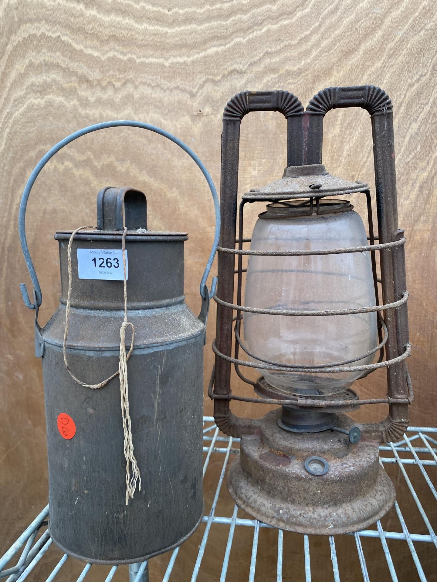 A SMALL VINTAGE MILK CHURN AND A PARAFIN LAMP