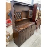 AN OAK DRESSER WITH THREE LOWER DOORS AND DRAWERS AND PLATE RACK WITH TWO GLAZED UPPER DOORS