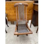 A LATE VICTORIAN FOLDING CAMPAIGN STYLE CHAIR WITH SPLIT CANE BACK STAMPED H.M