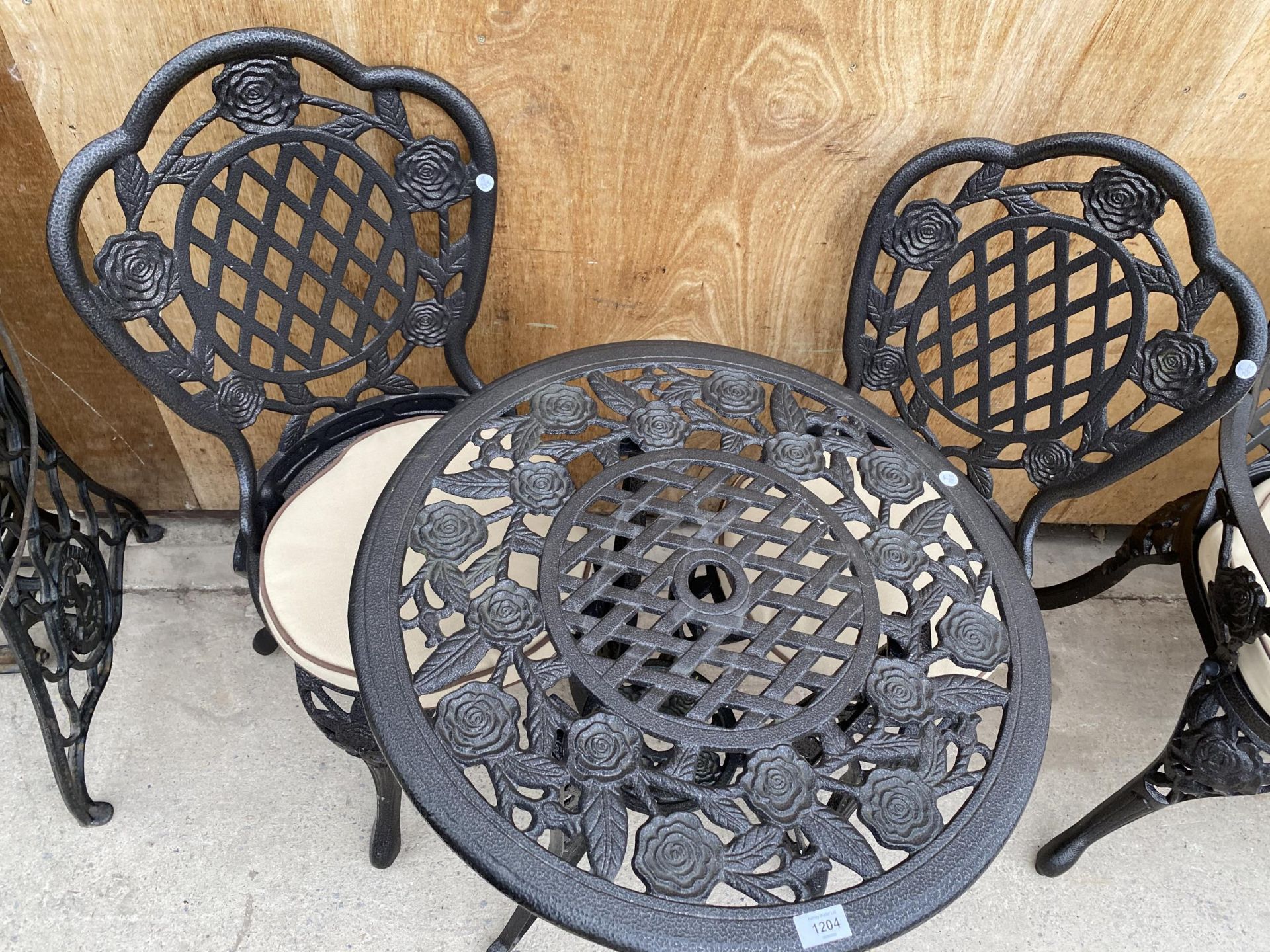 A CAST ALLOY BISTRO SET COMPRISING OF A ROUND FLORAL TABLE AND TWO CHAIRS WITH CUSHIONS - Image 3 of 3