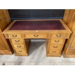 A REPRODUCTION OAK TWIN-PEDESTAL DESK ENCLOSING EIGHT SHORT AND ONE LONG DRAWER, 48.5X24.5"