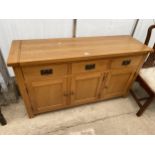 A MODERN OAK SIDEBOARD ENCLOSING THREE CUPBOARDS AND THREE DRAWERS 54" WIDE