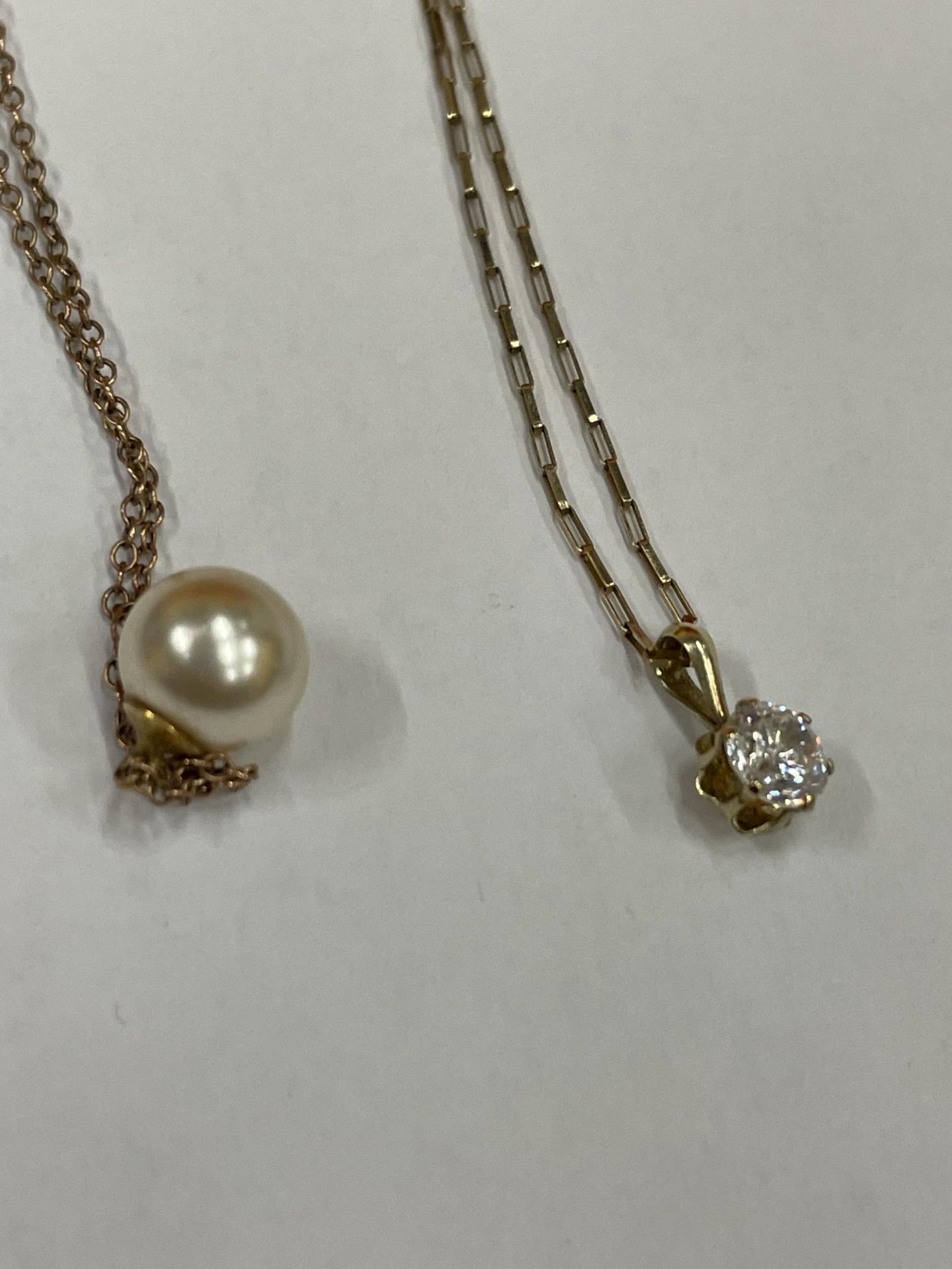 THREE NECKLACES WITH PENDANTS TO INCLUDE, TWO 9 CARAT GOLD ONE WITH A PEARL AND ONE WITH A CLEAR - Image 2 of 5