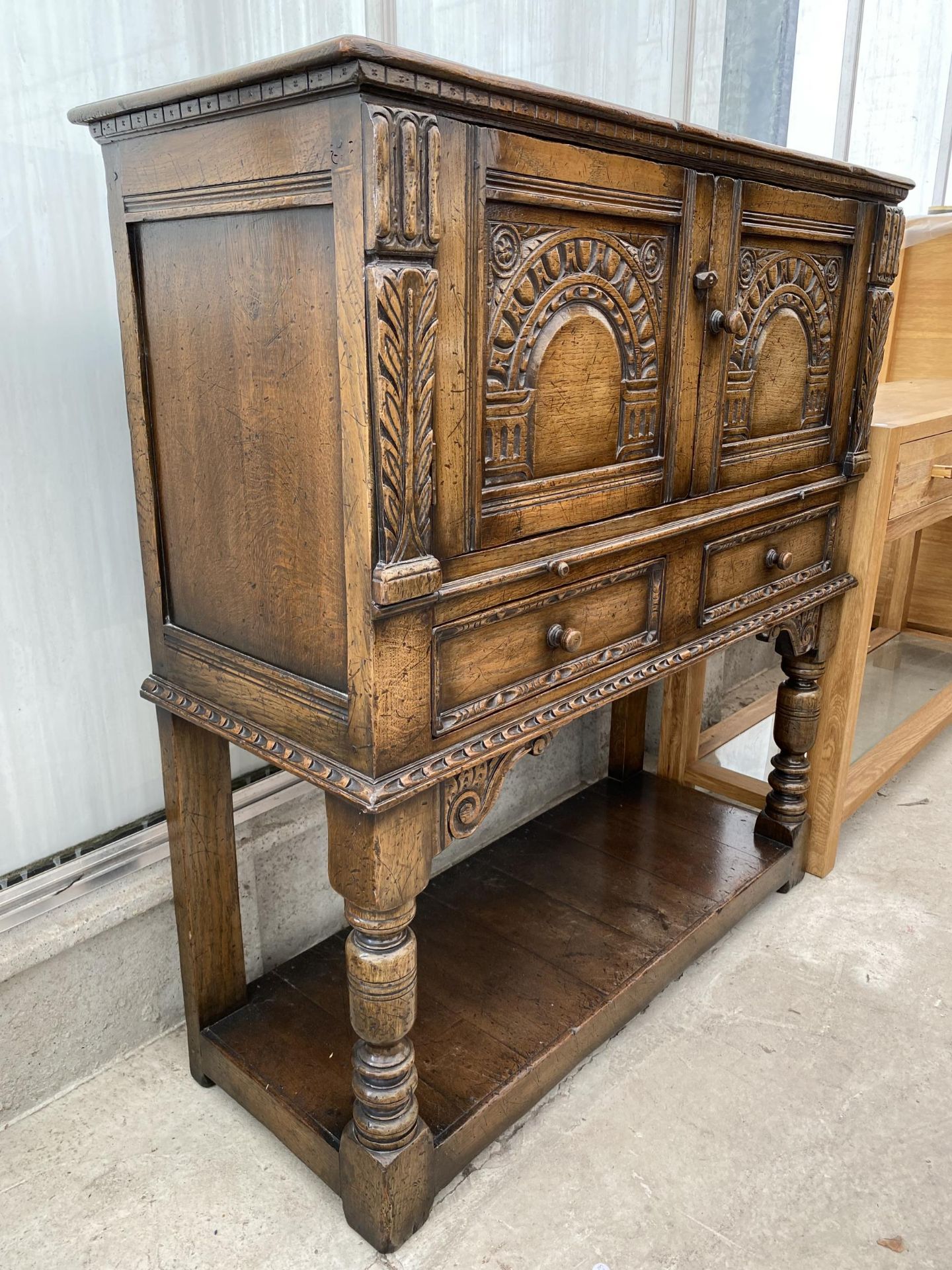 AN OAK JACOBEAN STYLE COCKTAIL CABINET WITH PANELLED DOOR, PULL OUT SLIDE, TWO DRAWERS AND A POT - Image 4 of 7