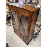 AN OAK OLD CHARM STYLE GLAZED AND LEADED BOOKCASE, 38" WIDE