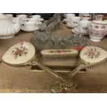 A GLASS DRESSING TABLE SET TO INCLUDE A TRAY AND TRINKET BOWL PLUS A PETIT-POINT HAND MIRROR,
